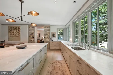 a view of a kitchen with a sink and large windows