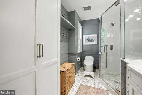 a bathroom with a toilet a sink and glass door