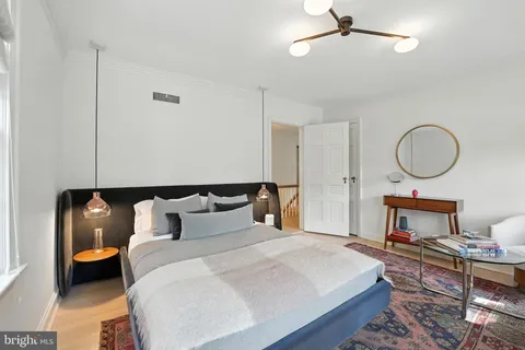 a bed room with a bed mirror and a chandelier