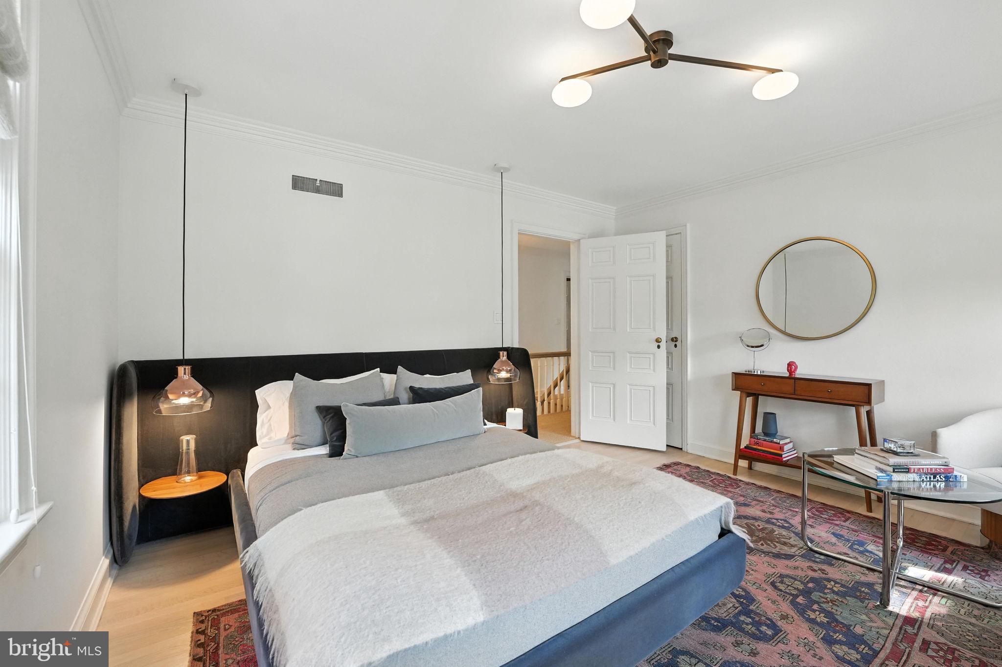 1804 45th Street Northwest Washington, DC 20007 - Photo 33 of 52 a bed room with a bed mirror and a chandelier