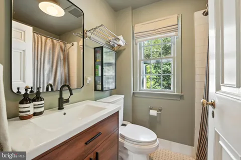 a bathroom with a double vanity sink toilet and a mirror