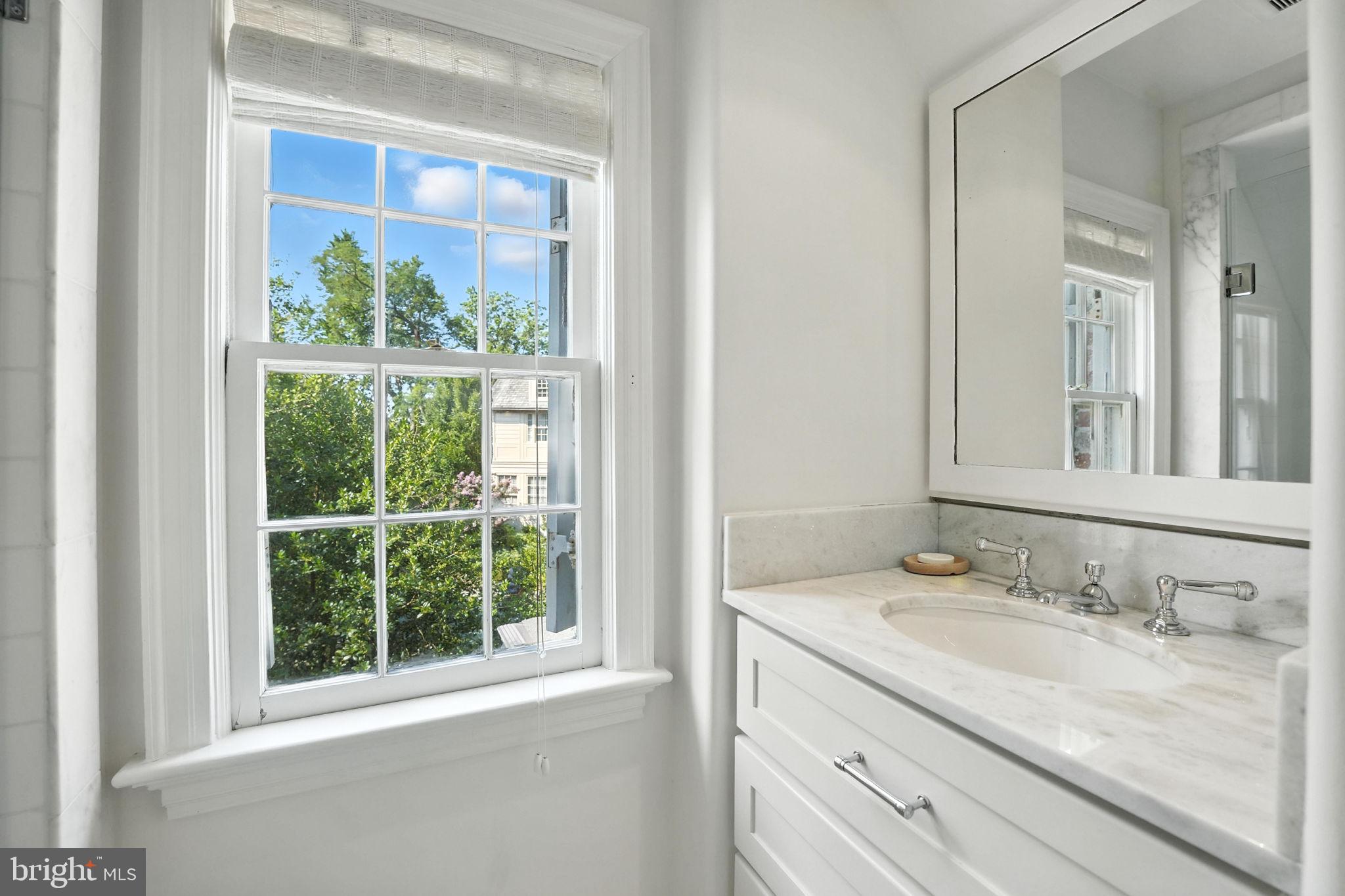 1804 45th Street Northwest Washington, DC 20007 - Photo 40 of 52 a bathroom with a granite countertop sink a large mirror and a window
