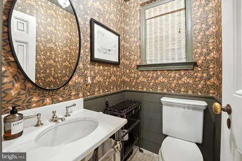 a bathroom with a toilet sink and mirror