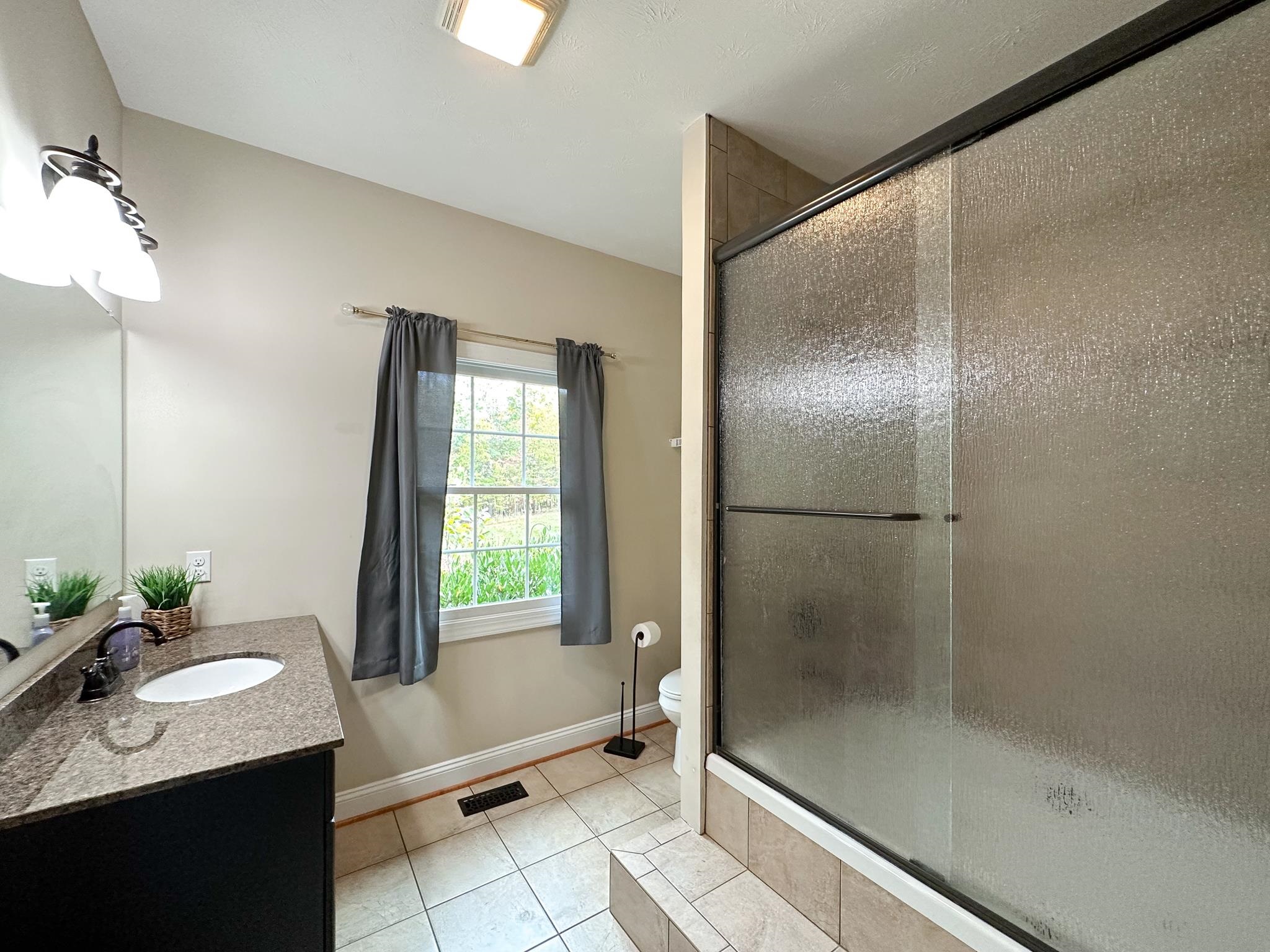 1426 Roman Road Mount Sidney, VA 24467 - Photo 40 of 46 a bathroom with a granite countertop sink mirror and shower