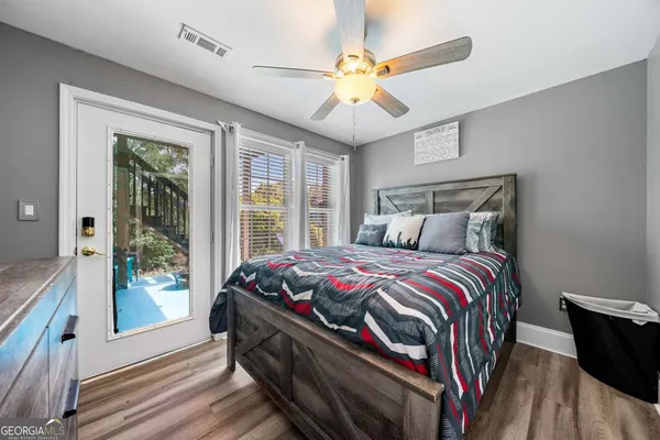 a bedroom with a bed and a large window with wooden floor