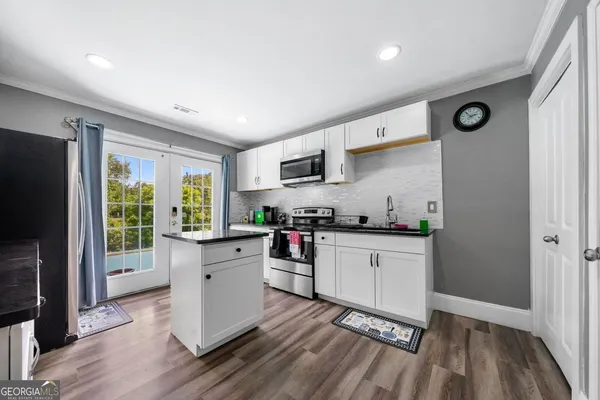 a kitchen with stainless steel appliances a stove top oven a sink dishwasher and a refrigerator