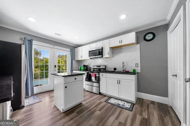 a kitchen with stainless steel appliances a stove top oven a sink dishwasher and a refrigerator