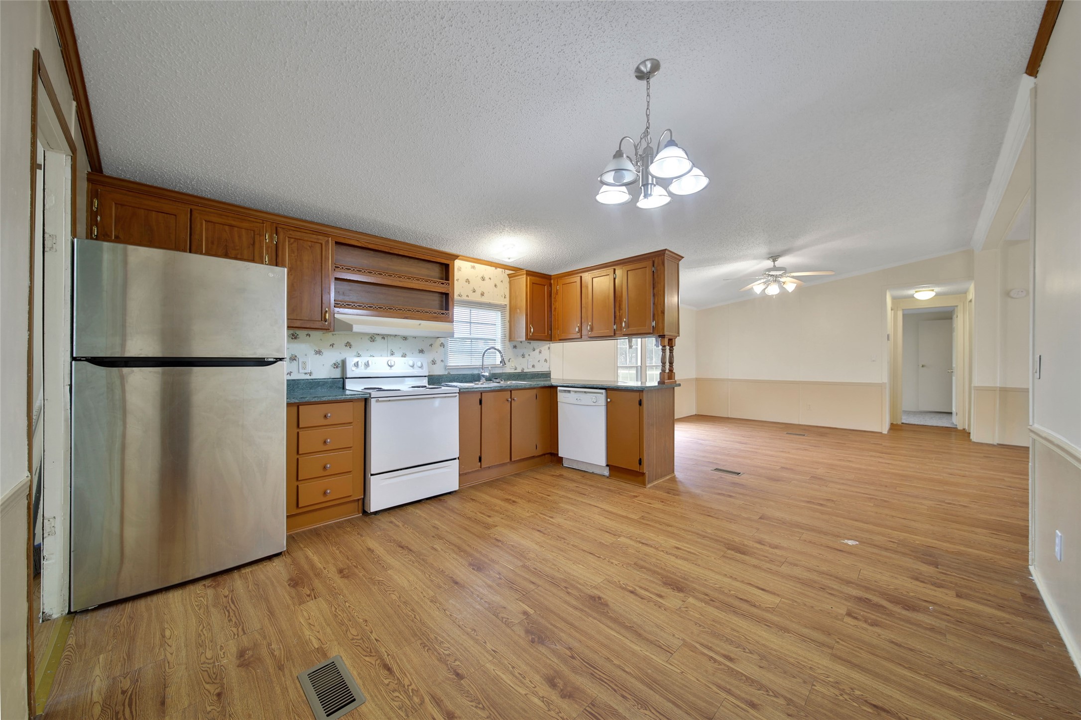2 Jacob Street Huntsville, TX 77320 - Photo 10 of 20 a kitchen with stainless steel appliances granite countertop a refrigerator a sink dishwasher a stove and a dining table with wooden floor
