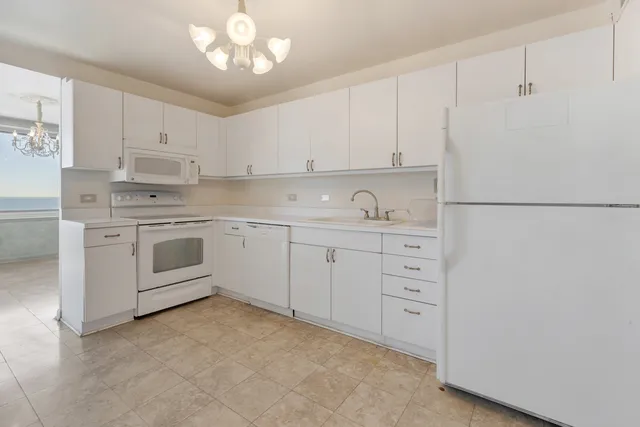 a kitchen with white cabinets and white appliances