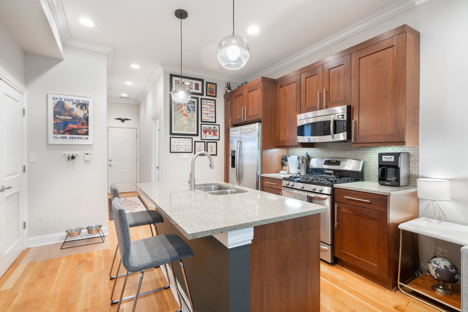 2624 West Rice Street, Unit 2F Chicago, IL 60622 - Photo 5 of 17 a kitchen with kitchen island a stove top oven a sink dishwasher and a refrigerator with wooden floor