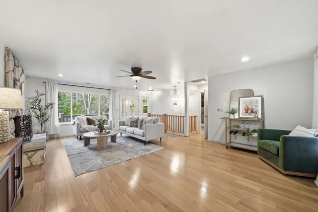 a bathroom with a granite countertop sink a large mirror and a bathtub next to a window