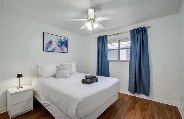 a bedroom with a large bed and a chandelier