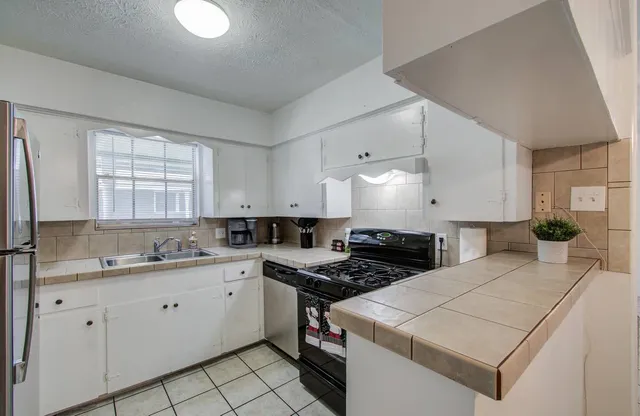 a kitchen with a sink stove and cabinets