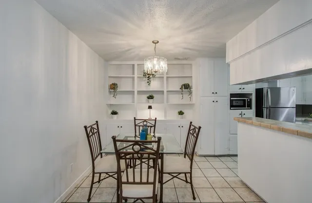 a view of a dining room with furniture and chandelier