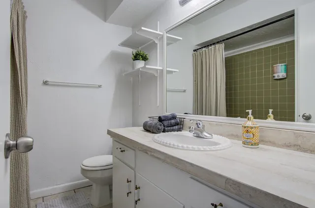 a bathroom with a granite countertop sink toilet and shower