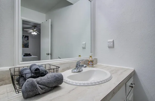 a bathroom with a granite countertop sink and a mirror