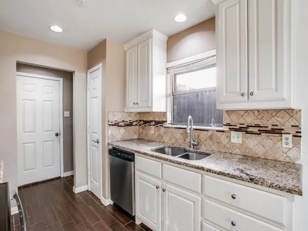 a kitchen with granite countertop a sink and cabinets
