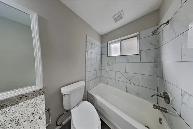 a white toilet sitting next to a bath tub