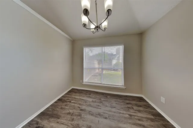 an empty room with windows and ceiling fan