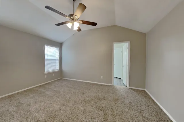 a view of an empty room and chandelier fan
