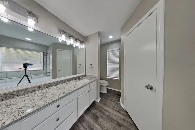 a spacious bathroom with a granite countertop sink mirror and toilet
