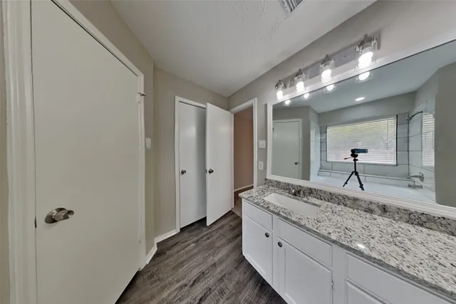 a bathroom with a granite countertop sink and a mirror