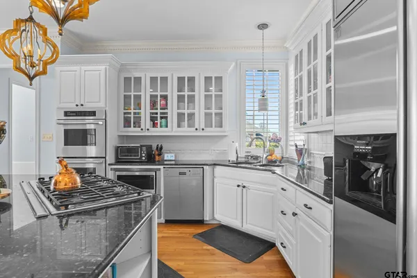 a kitchen with stainless steel appliances granite countertop a stove and a sink