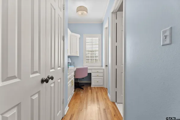 a view of a bedroom with a bed and wooden floor