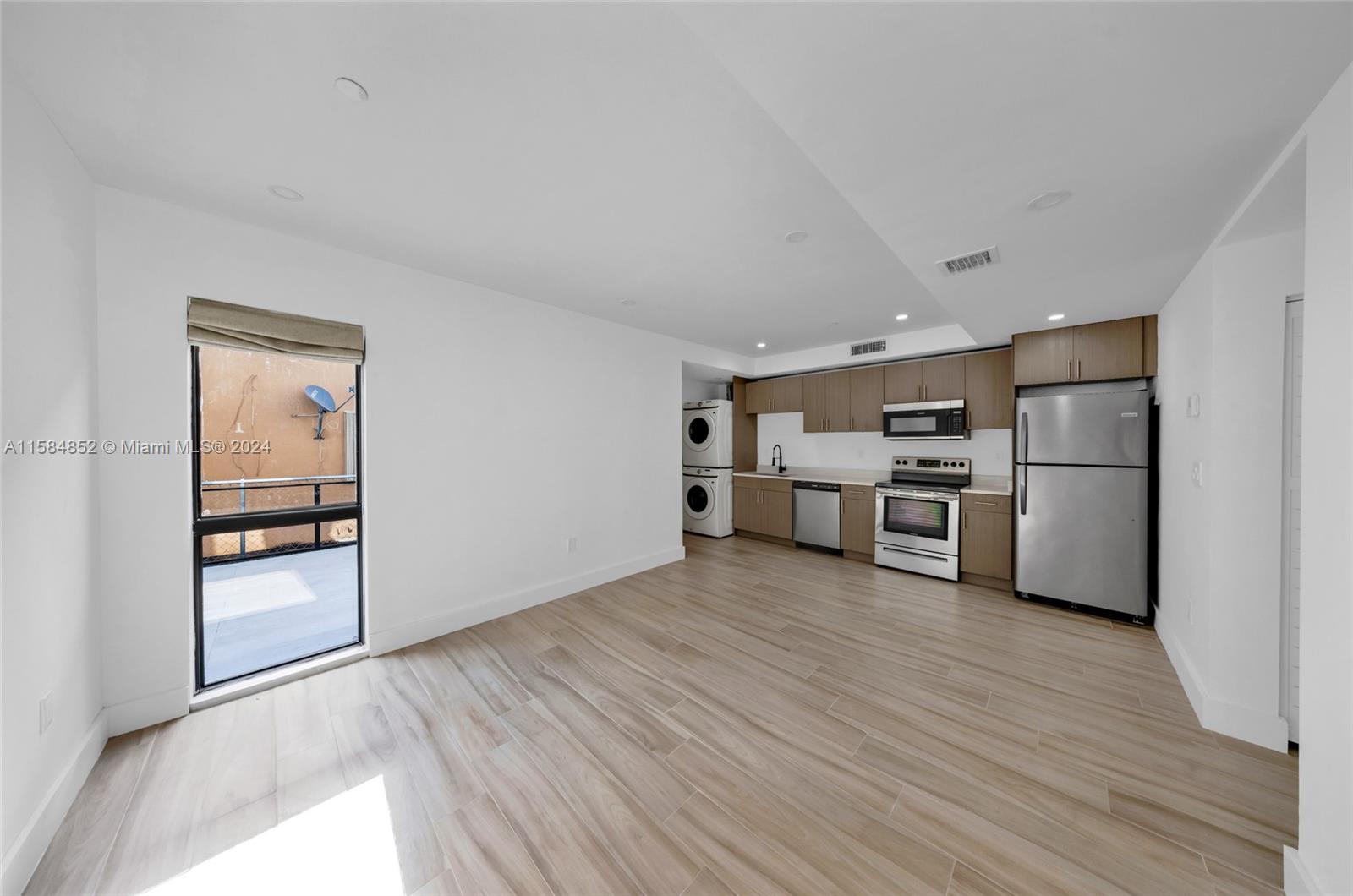 1335 Southwest 4th Street Miami, FL 33135 - Photo 12 of 59 a view of a kitchen with wooden floor refrigerator cabinet and a living room