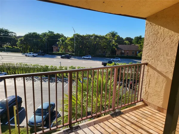 a view of balcony with wooden floor and fence