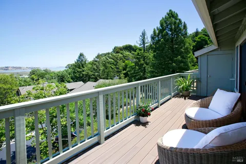 a view of a balcony with wooden floor and fence
