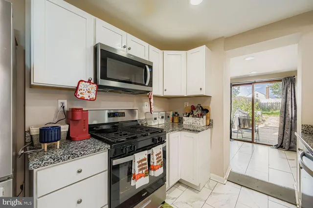 a kitchen with stainless steel appliances granite countertop a stove and a microwave