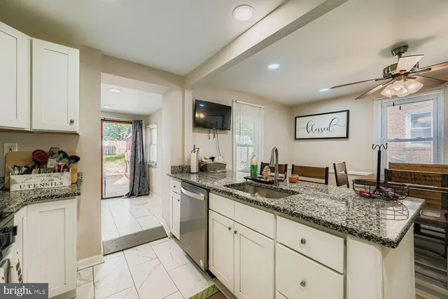 a kitchen with granite countertop a sink and cabinets