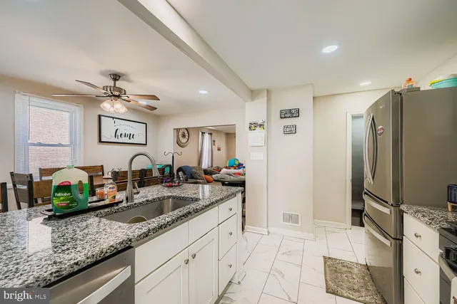 a kitchen with granite countertop a sink stainless steel appliances and cabinets