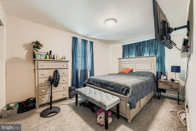 a bedroom with a bed and a stove next to a window