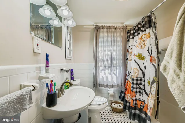 a bathroom with a sink a toilet and shower curtain