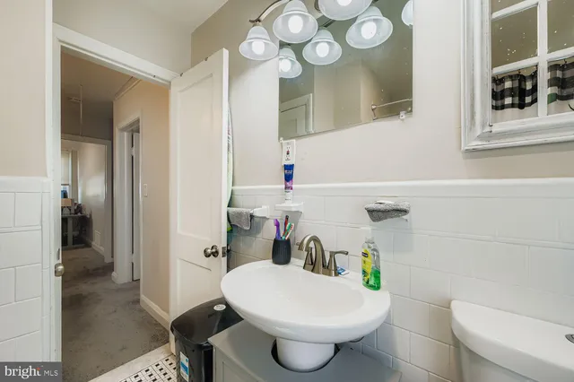 a bathroom with a sink a toilet a mirror and shower