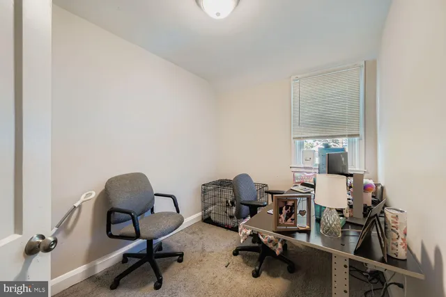 a view of a workspace with furniture and a window