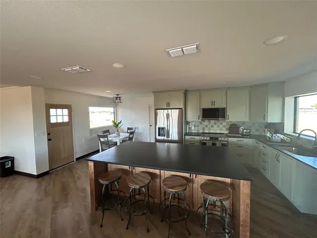 a kitchen with a dining table chairs and refrigerator