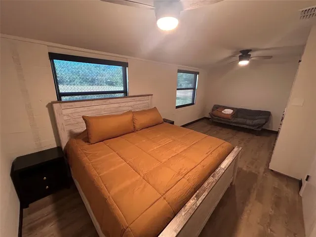 a bedroom with a bed and wooden floor