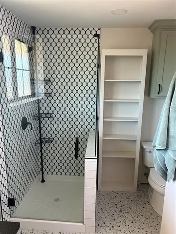 a bathroom with a toilet and a shower
