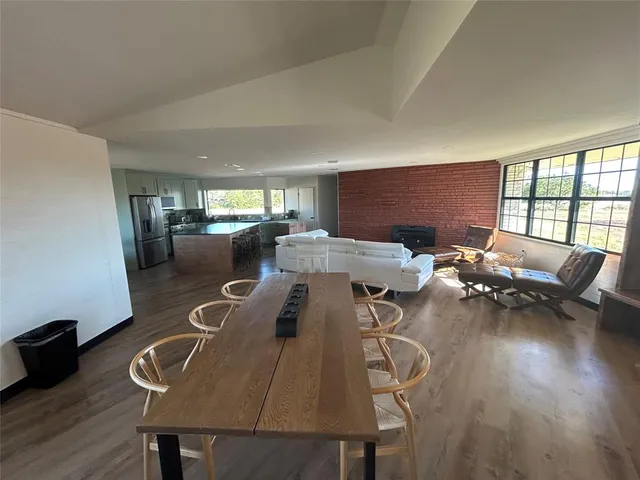 a view of a dining room with furniture a rug and wooden floor