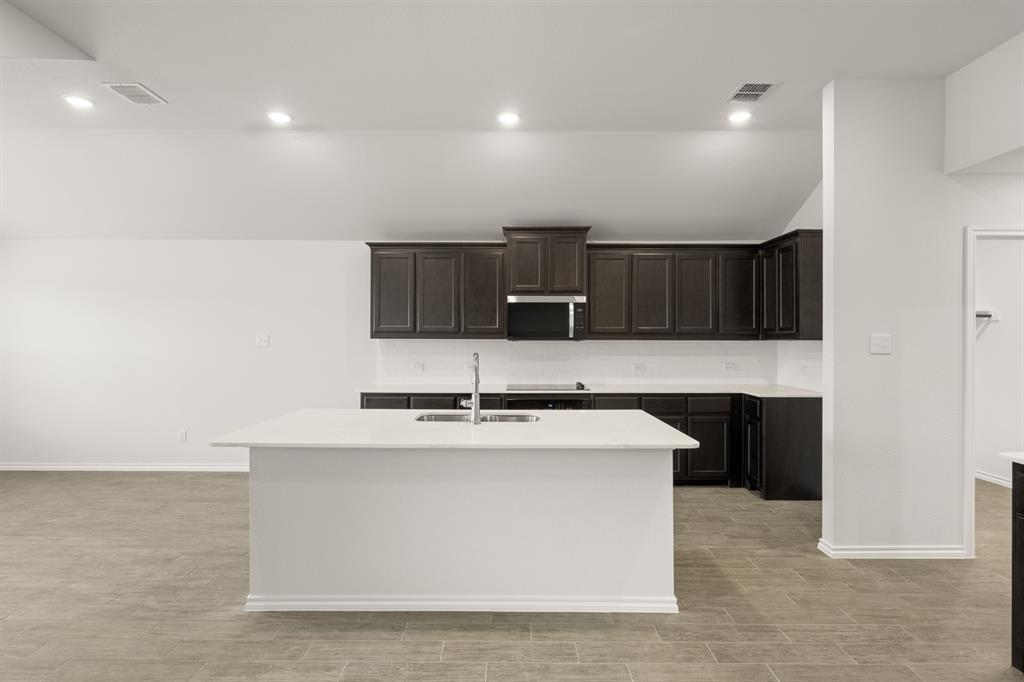 2607 Streamside Drive Burleson, TX 76028 - Photo 4 of 27 a large kitchen with kitchen island a sink stainless steel appliances and cabinets