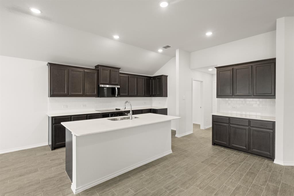 2607 Streamside Drive Burleson, TX 76028 - Photo 5 of 27 a kitchen with stainless steel appliances granite countertop a sink stove and microwave