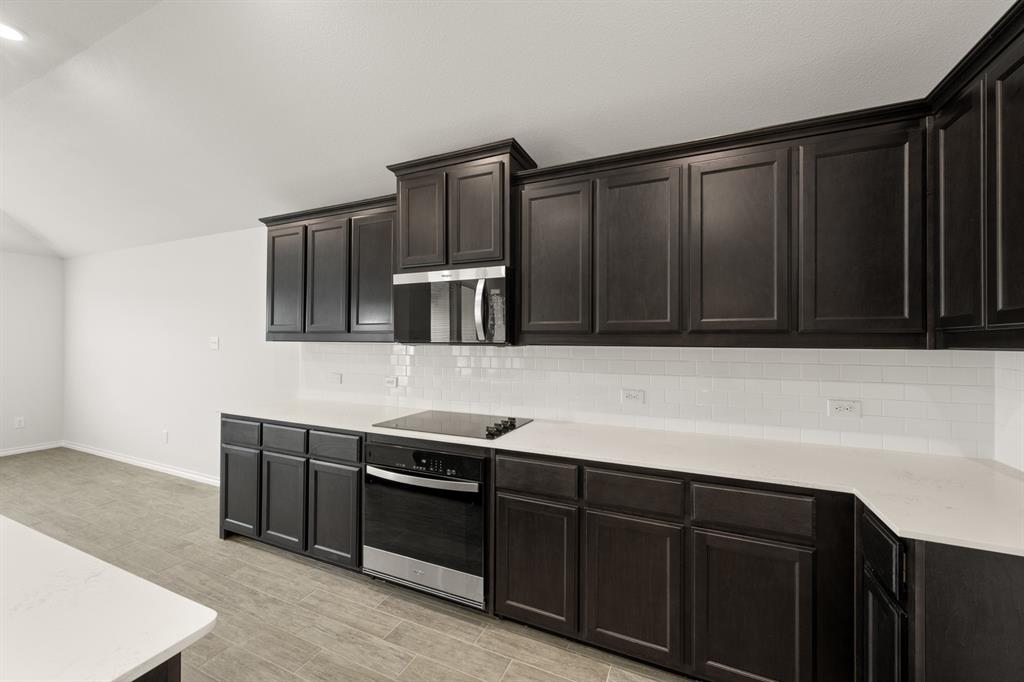 2607 Streamside Drive Burleson, TX 76028 - Photo 7 of 27 a kitchen with stainless steel appliances wooden cabinets and a sink