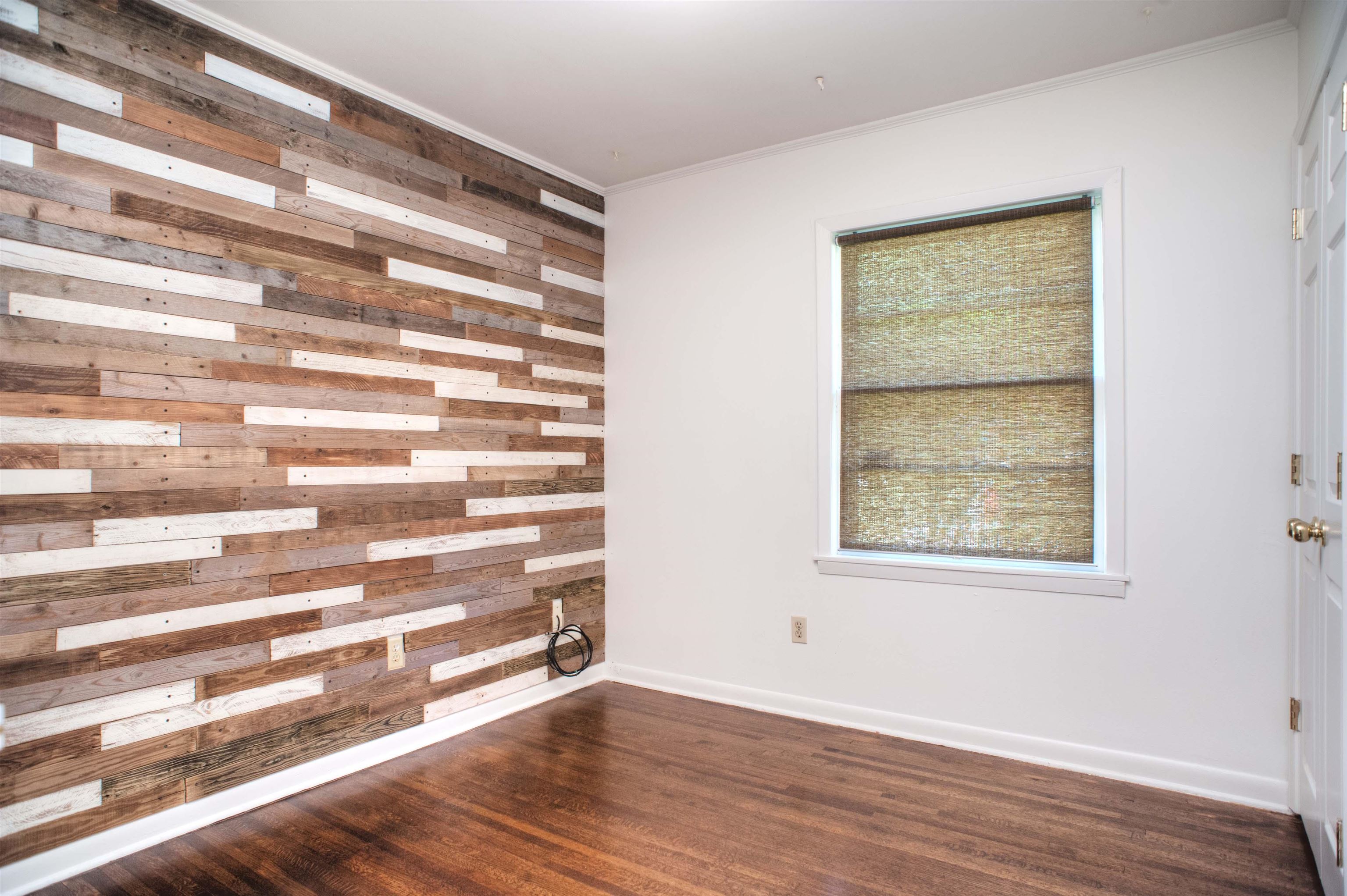 1612 Raymore Road Memphis, TN 38117 - Photo 12 of 17 a view of an empty room with wooden floor and a window