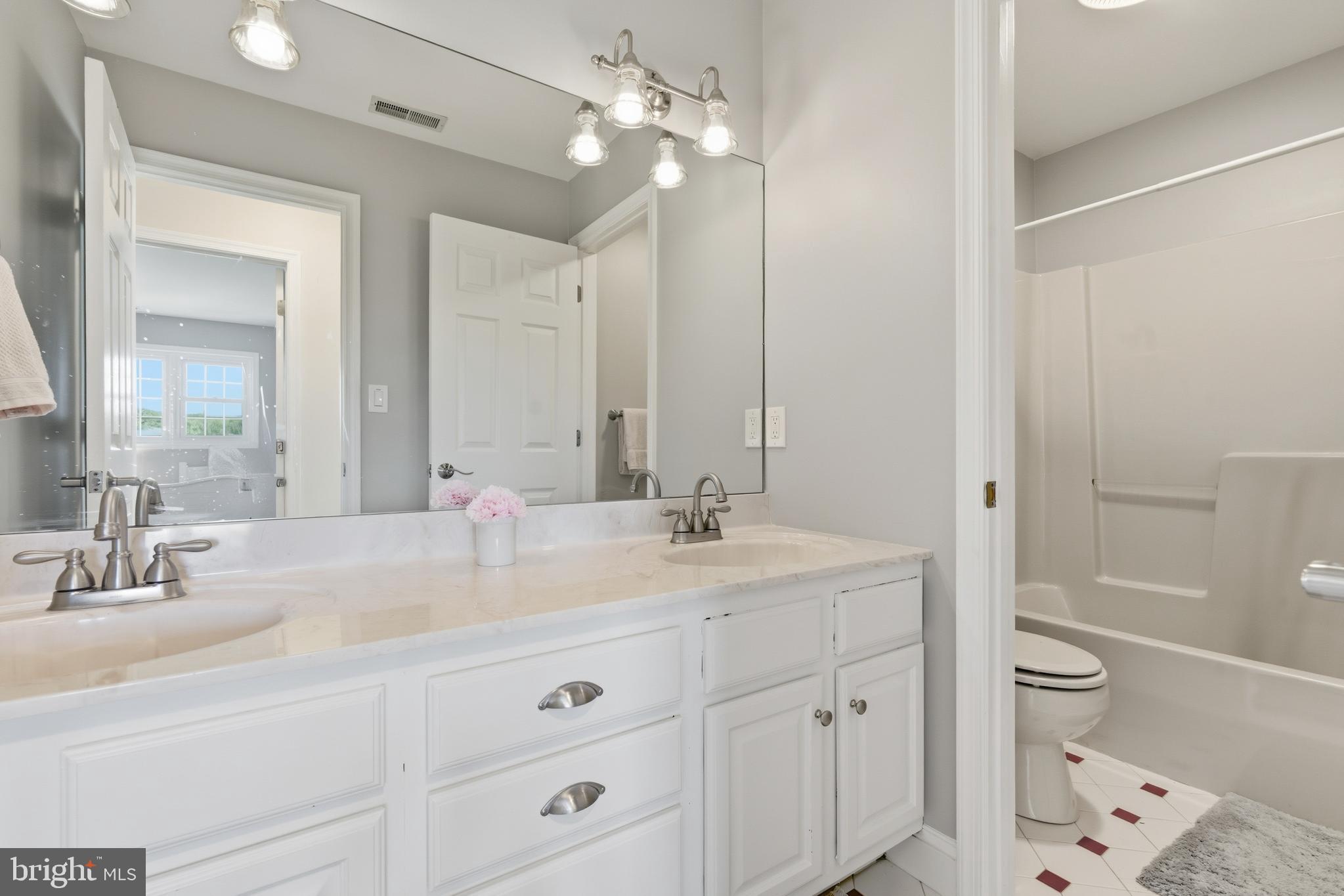 115 Scott Road Warwick, MD 21912 - Photo 21 of 32 a bathroom with a double vanity sink toilet mirror and bathtub