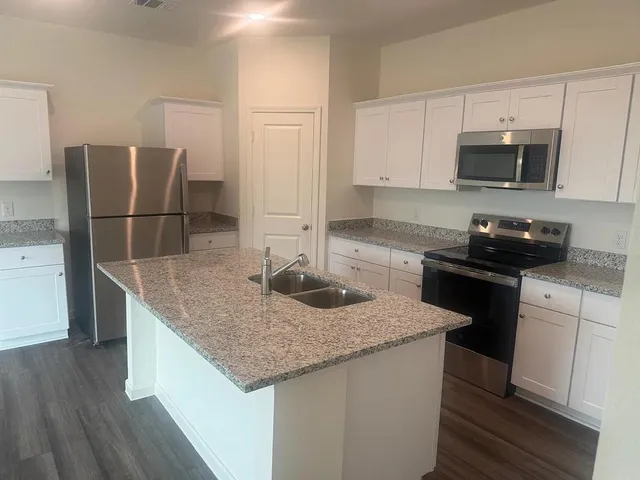 a kitchen with stainless steel appliances granite countertop a sink stove and refrigerator