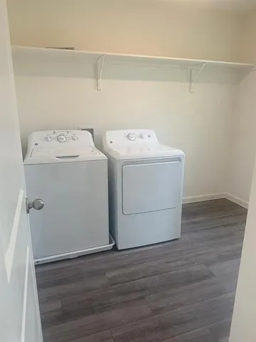 a utility room with wooden floor washer and dryer