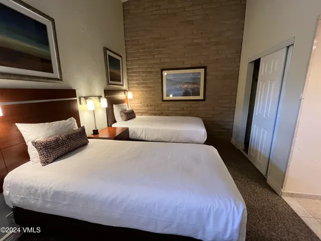 a bed sitting in a bedroom next to a tv